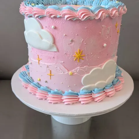 Pink and blue cake with fondant clouds and gold stars